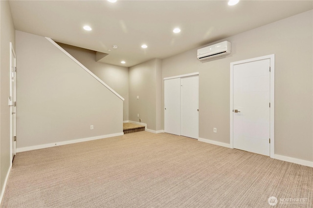 basement featuring light carpet, stairs, an AC wall unit, and recessed lighting