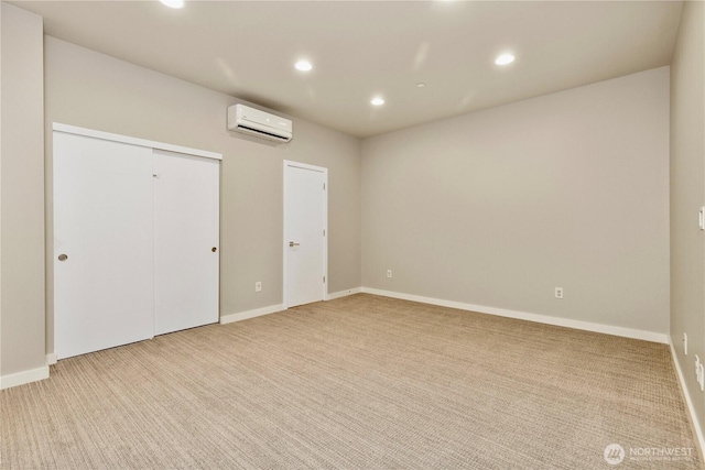 unfurnished bedroom with recessed lighting, light colored carpet, baseboards, and a wall mounted AC