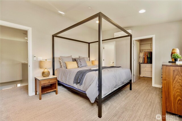 bedroom with light carpet, a wall unit AC, a walk in closet, a closet, and recessed lighting