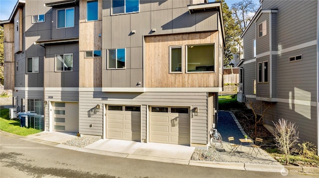 view of front facade with a garage, concrete driveway, and central air condition unit