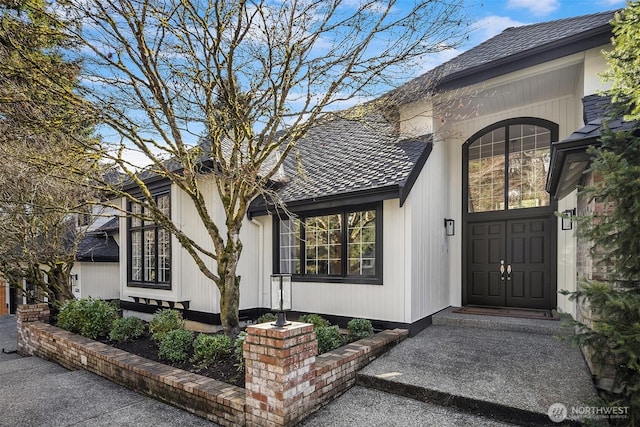 view of exterior entry with a shingled roof