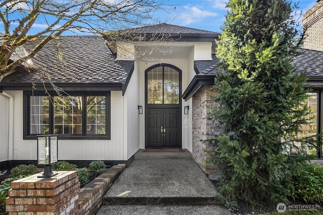 doorway to property featuring a shingled roof