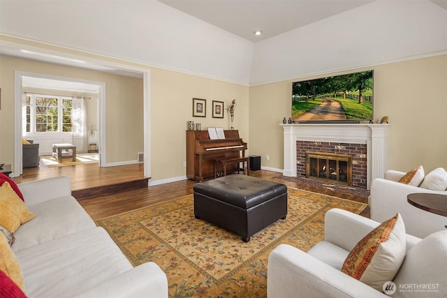 living room with recessed lighting, a brick fireplace, wood finished floors, and baseboards