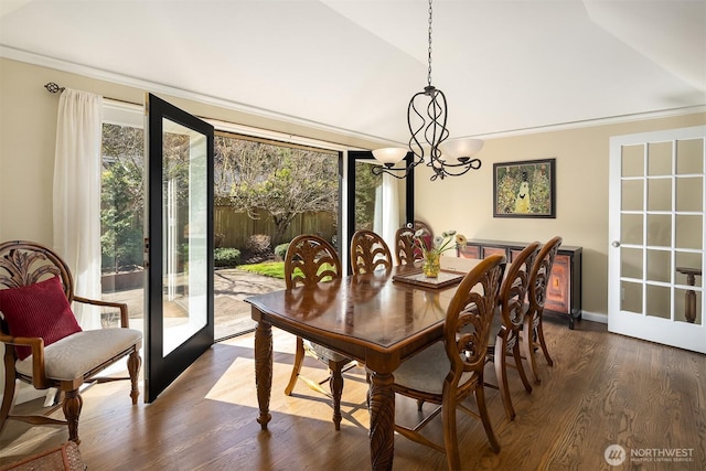 dining room with lofted ceiling, an inviting chandelier, dark wood-style flooring, and french doors