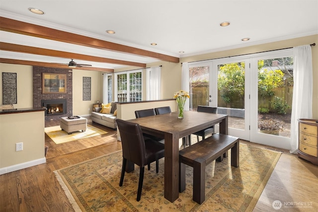 dining room featuring recessed lighting, a fireplace, baseboards, and wood finished floors