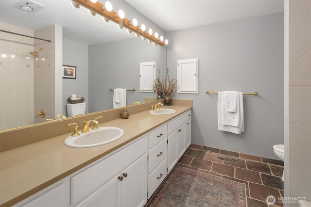 full bathroom with walk in shower, a sink, toilet, and double vanity