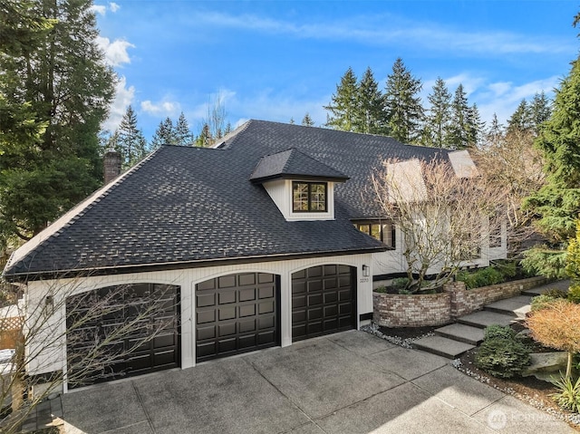 view of home's exterior featuring a garage and roof with shingles