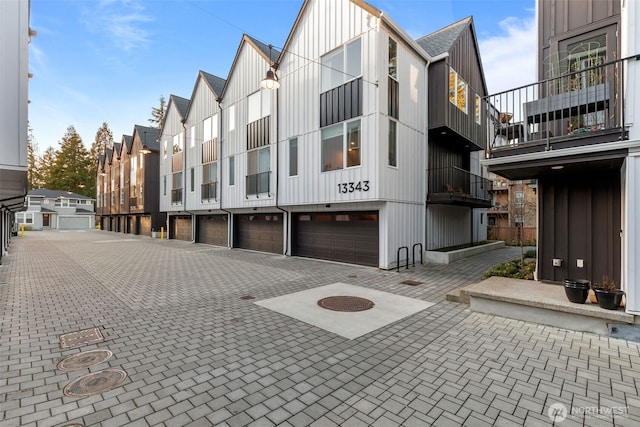 exterior space with decorative driveway, a garage, and a residential view