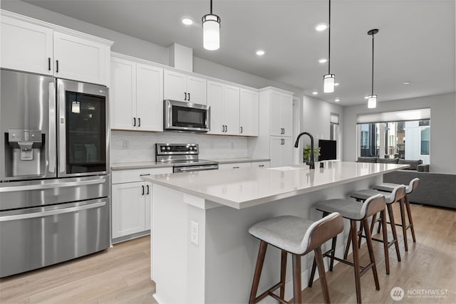 kitchen with white cabinetry, backsplash, appliances with stainless steel finishes, and a sink