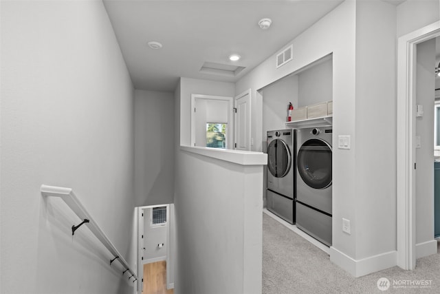 laundry room featuring visible vents, laundry area, attic access, light colored carpet, and washer and clothes dryer