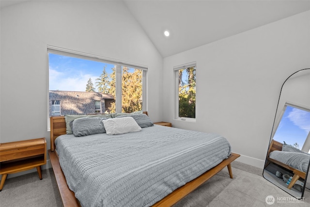 carpeted bedroom featuring baseboards and high vaulted ceiling