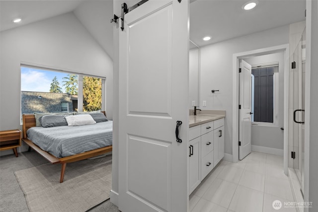 bedroom featuring recessed lighting, lofted ceiling, a barn door, and a sink