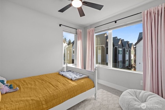 bedroom with carpet flooring, multiple windows, a ceiling fan, and baseboards