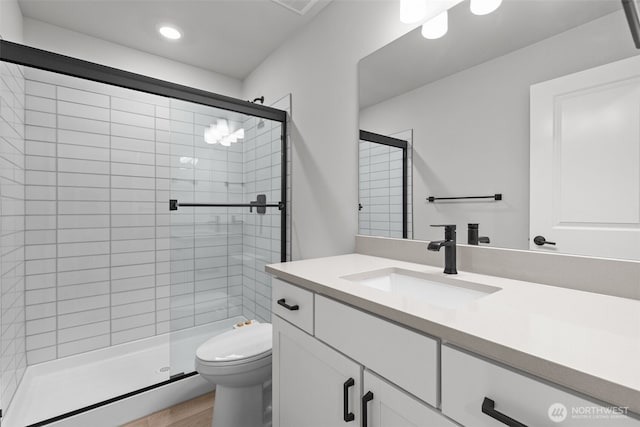 bathroom featuring recessed lighting, a shower stall, toilet, and vanity