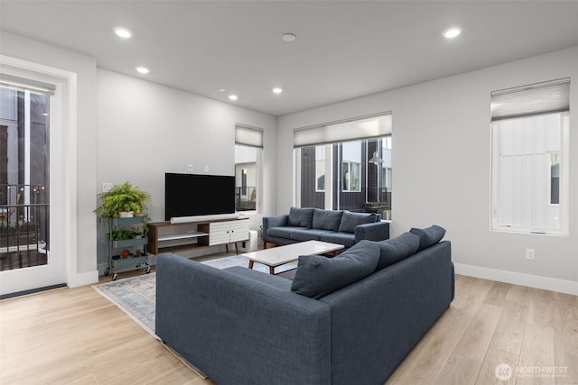 living room with recessed lighting, light wood-type flooring, and baseboards