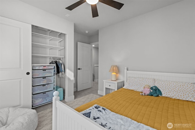 bedroom with baseboards, light colored carpet, a closet, and ceiling fan