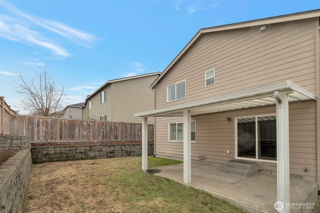 rear view of property featuring a patio, a lawn, and a fenced backyard