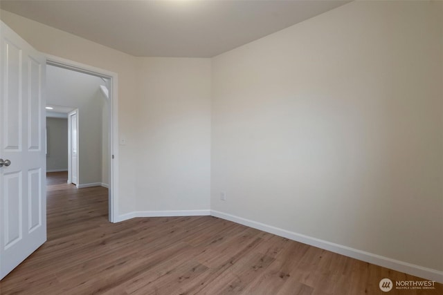 unfurnished room with baseboards and wood finished floors