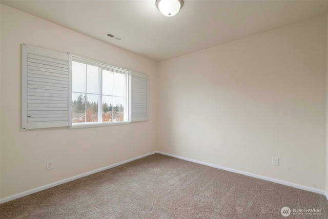 carpeted spare room with visible vents and baseboards