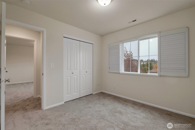 unfurnished bedroom with visible vents, baseboards, a closet, and carpet flooring