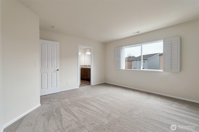 carpeted spare room featuring visible vents and baseboards