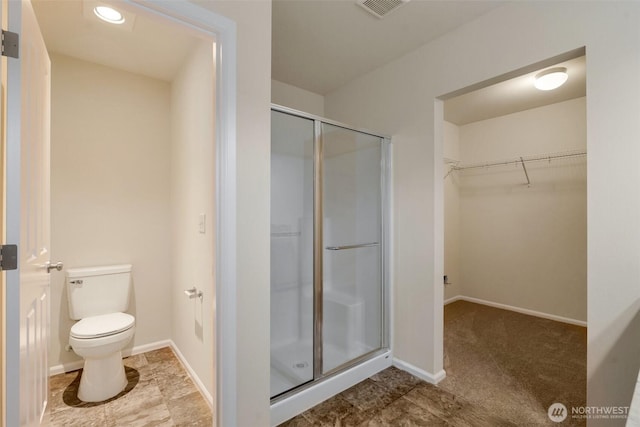 full bath featuring visible vents, a shower stall, toilet, and a walk in closet