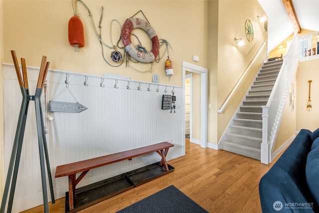 mudroom featuring baseboards, wood finished floors, and beamed ceiling