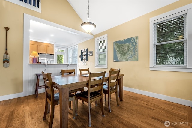 dining area with lofted ceiling, wood finished floors, and baseboards