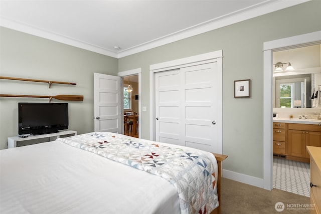 bedroom featuring connected bathroom, light carpet, baseboards, ornamental molding, and a closet