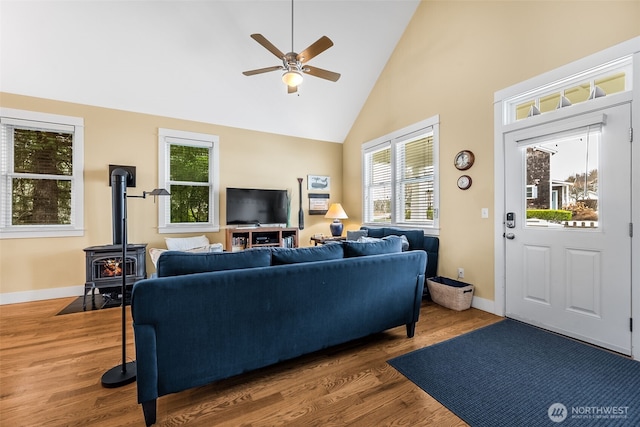 living room featuring ceiling fan, high vaulted ceiling, wood finished floors, and baseboards