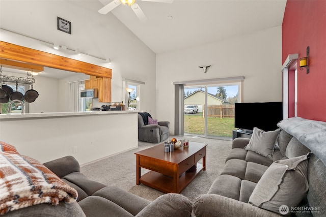 carpeted living area featuring high vaulted ceiling, ceiling fan, and a sink