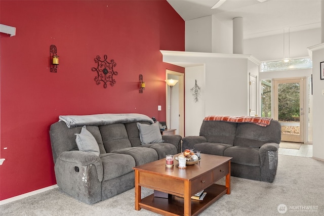 living room featuring baseboards, carpet floors, and a high ceiling