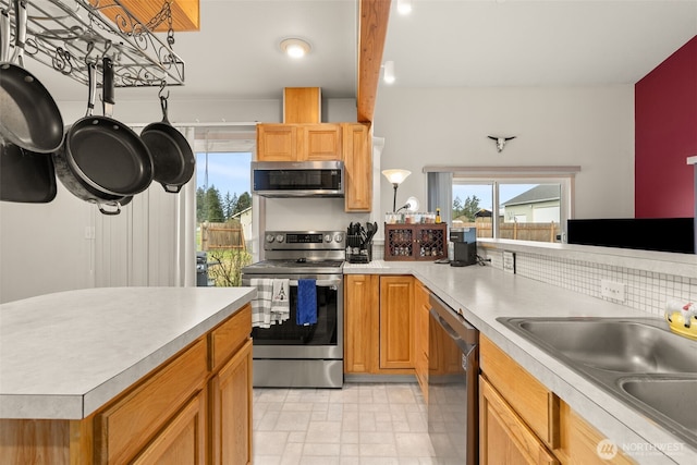 kitchen with a sink, light countertops, decorative backsplash, and stainless steel appliances