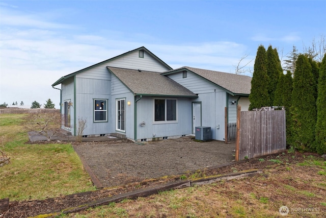 view of front of home with crawl space, a shingled roof, central AC, and fence