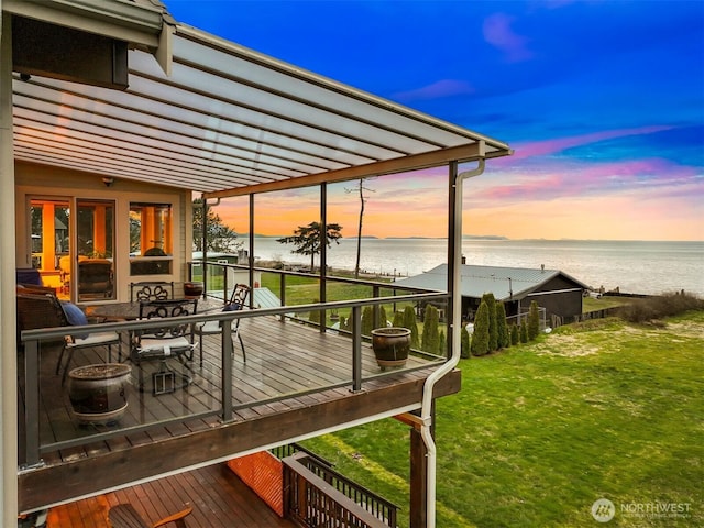 wooden terrace featuring a water view and a yard