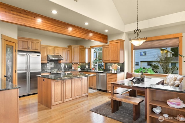 kitchen with stainless steel appliances, lofted ceiling with beams, decorative backsplash, a kitchen island, and under cabinet range hood