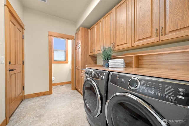 laundry area featuring cabinet space, washer and clothes dryer, and baseboards