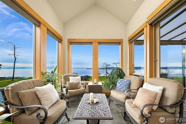 sunroom featuring a wealth of natural light, lofted ceiling, and a water view