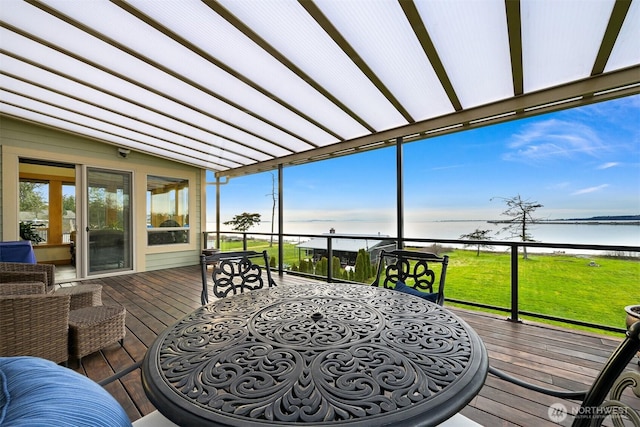 sunroom with lofted ceiling, a water view, and a healthy amount of sunlight