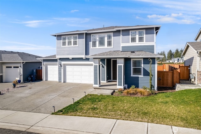 view of front facade with a garage, driveway, a front lawn, and fence