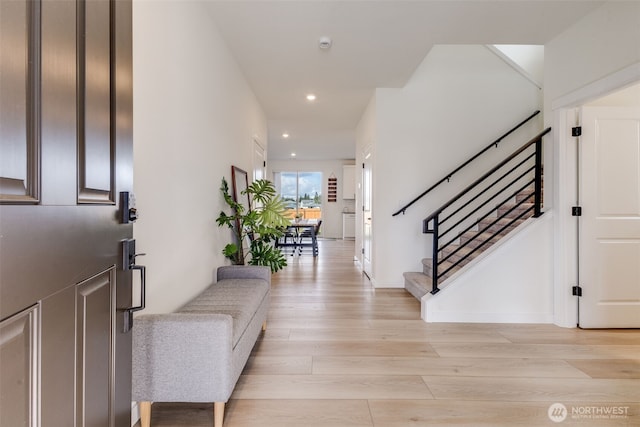 foyer entrance with recessed lighting, light wood finished floors, and stairs