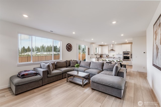 living room with baseboards, light wood-style flooring, and recessed lighting