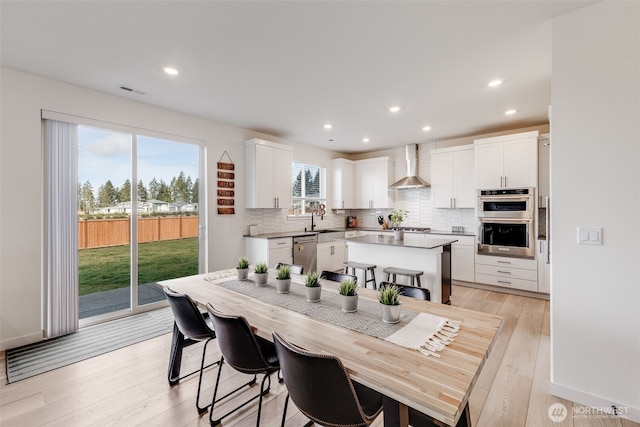 dining space featuring recessed lighting, light wood-style flooring, and baseboards