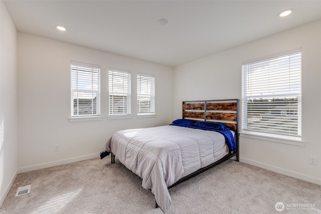 bedroom featuring carpet floors, baseboards, multiple windows, and visible vents