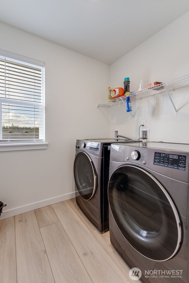 laundry room featuring laundry area, light wood-style flooring, baseboards, and separate washer and dryer