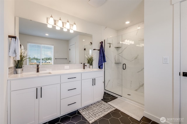 bathroom with tile patterned floors, a sink, a marble finish shower, and double vanity