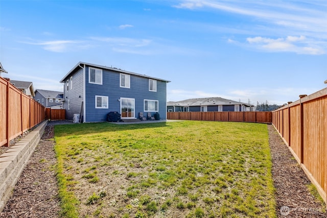 back of house featuring a patio area, a yard, and a fenced backyard