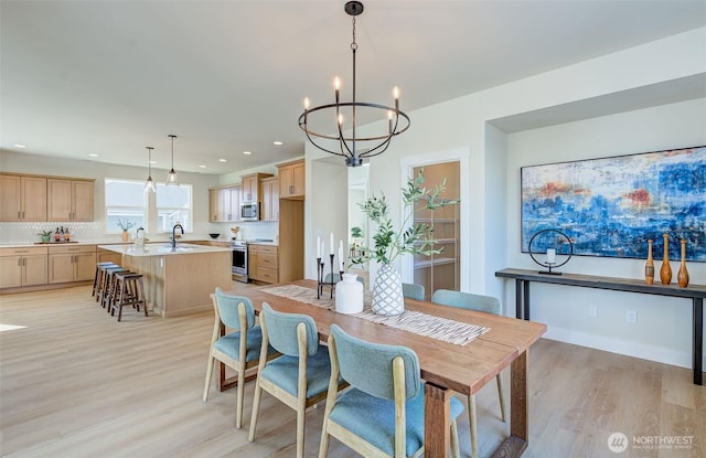 dining room with light wood-style flooring, recessed lighting, and a chandelier