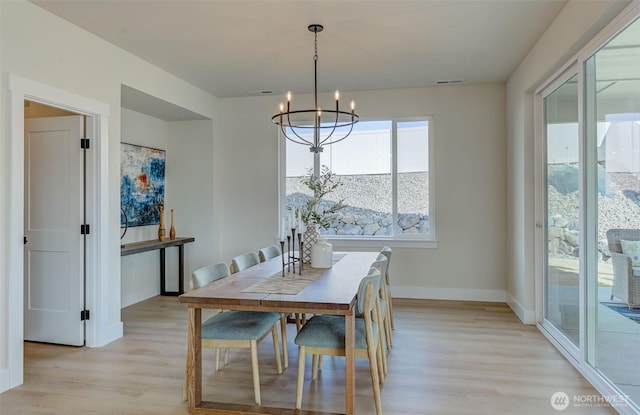 dining area featuring a notable chandelier, visible vents, light wood-style flooring, and baseboards