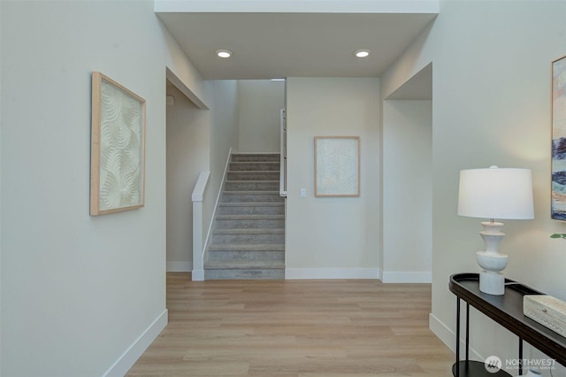 stairway featuring recessed lighting, wood finished floors, and baseboards